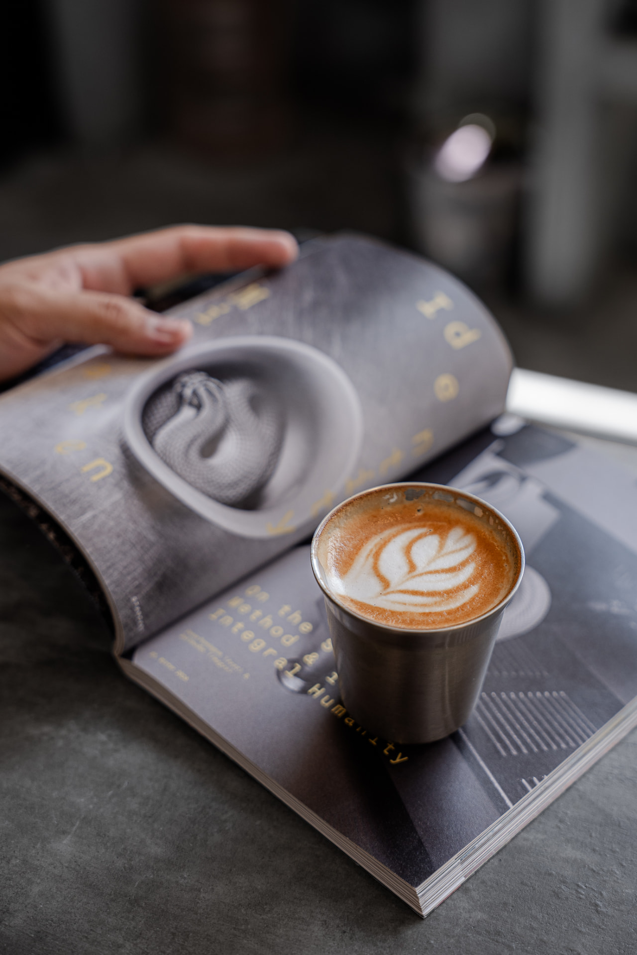 Un café sobre una revista abierta en W Coffee Works